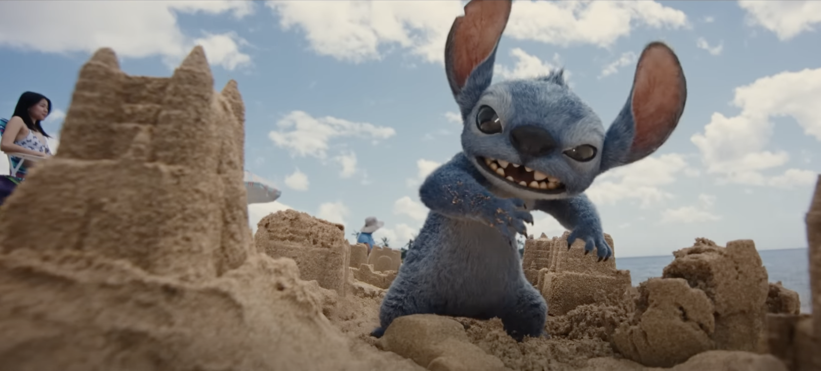 animated film still of Stitch charging through sand castles on the beach