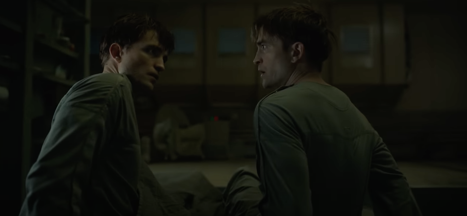 film still from Mickey 17 showing Robert Pattinson looking at another embodiment of himself