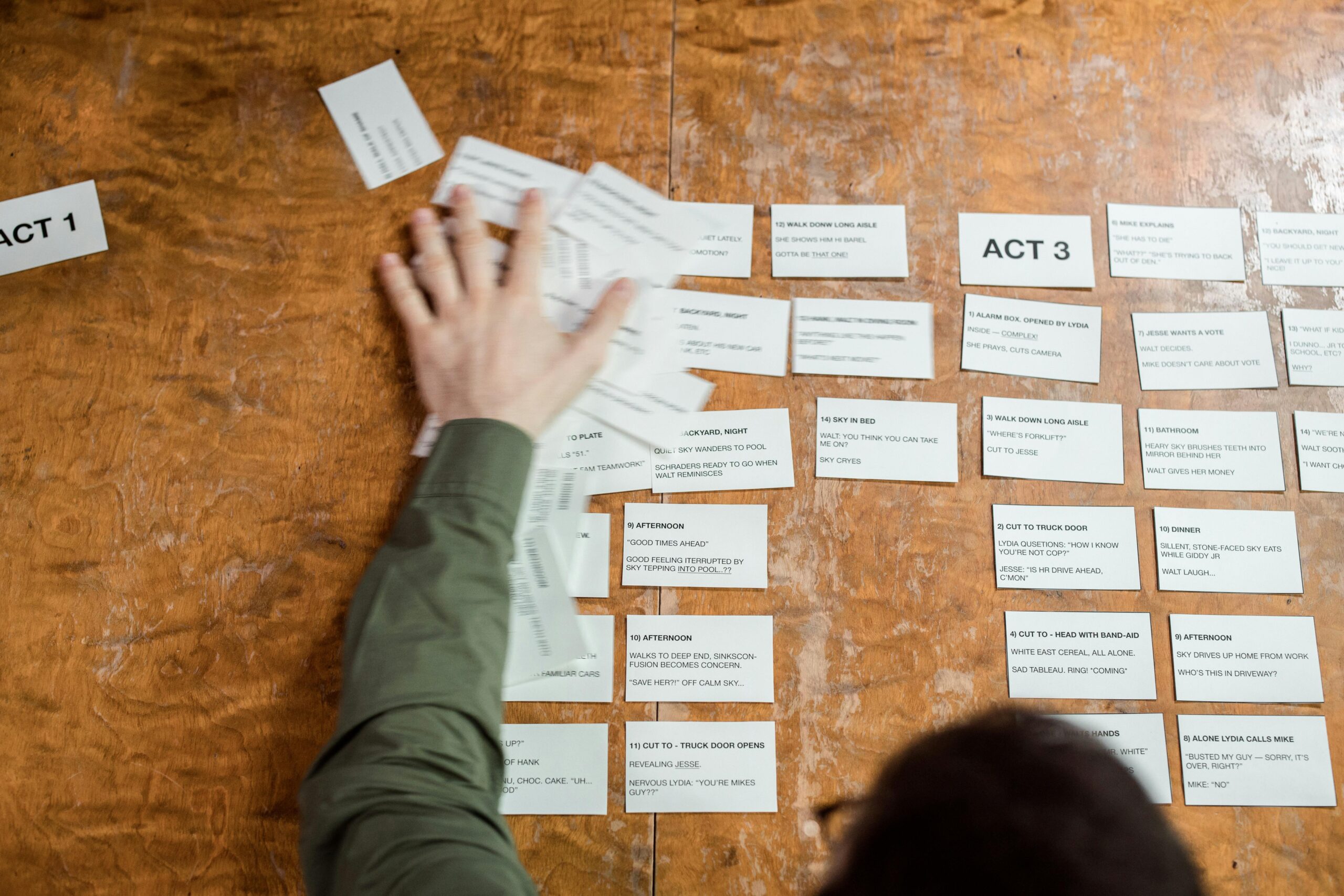 image of a man swiping note cards off a table 