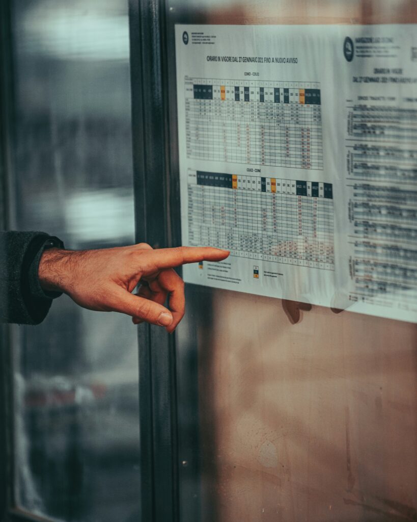 image of a hand pointing at a schedule on the wall