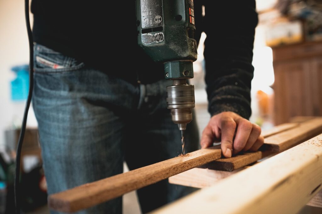 image of a man drilling a hole in a piece of timber