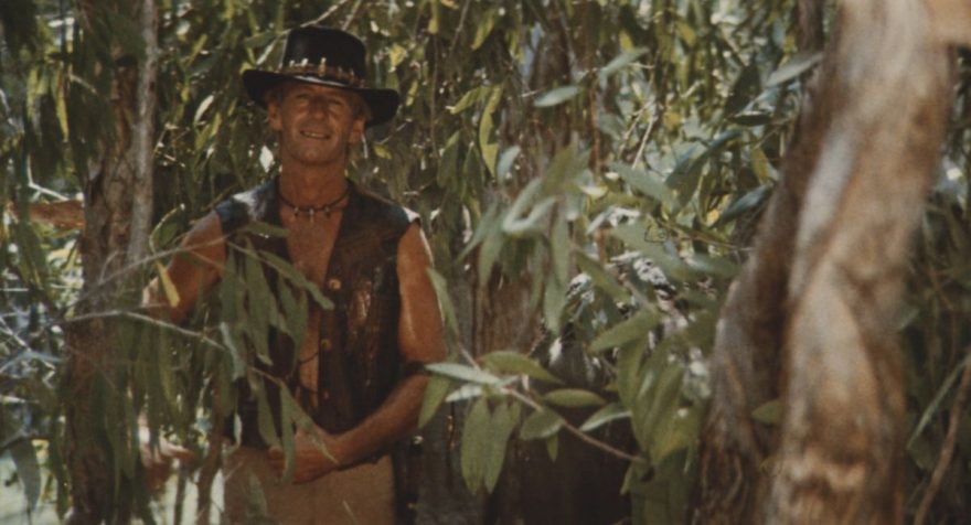 film still from Crocodile Dundee (1986) of Mich Dundee in a forest 