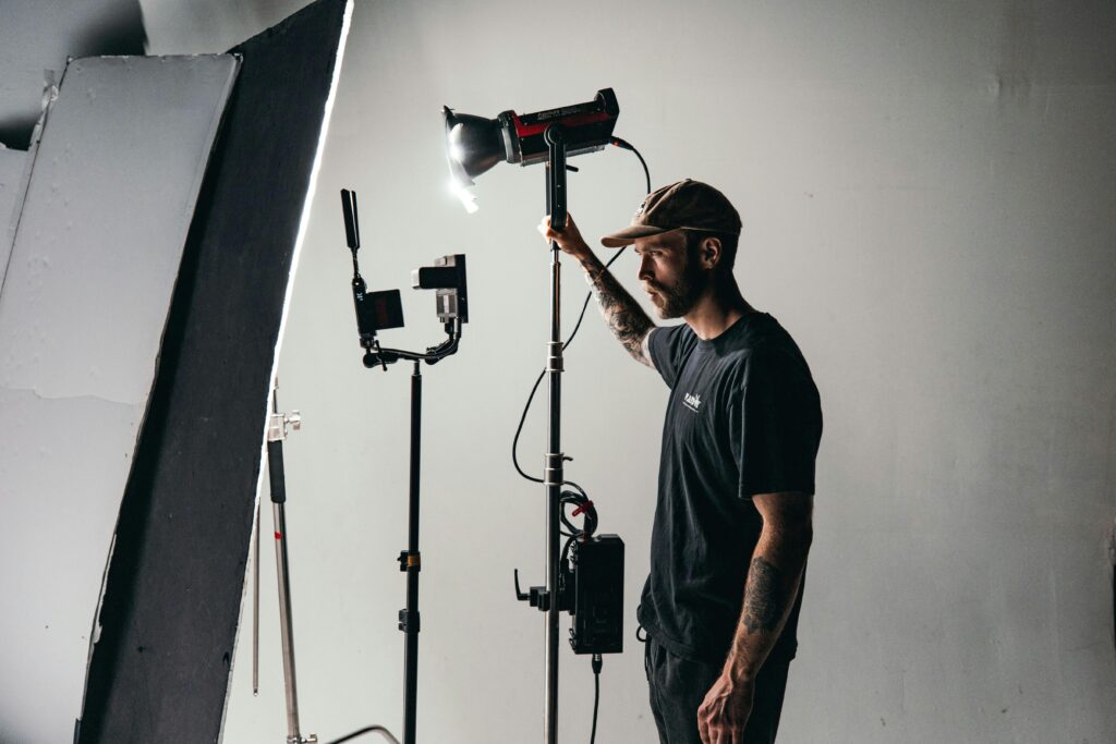 image of a film crew member adjusting the lighting set up on a film set