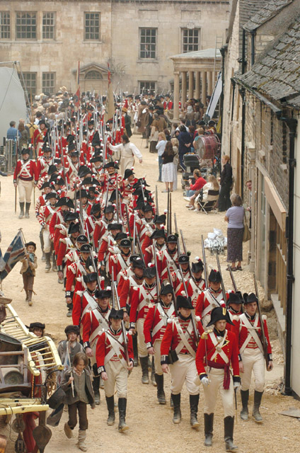 Pride and Prejudice (2005) film still of red-coasted militia officers walking through Meryton town (Stamford) 