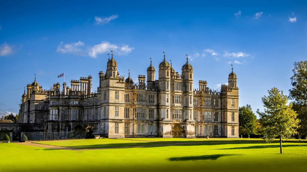 the exterior of Burghley House with a blue sky backdrop