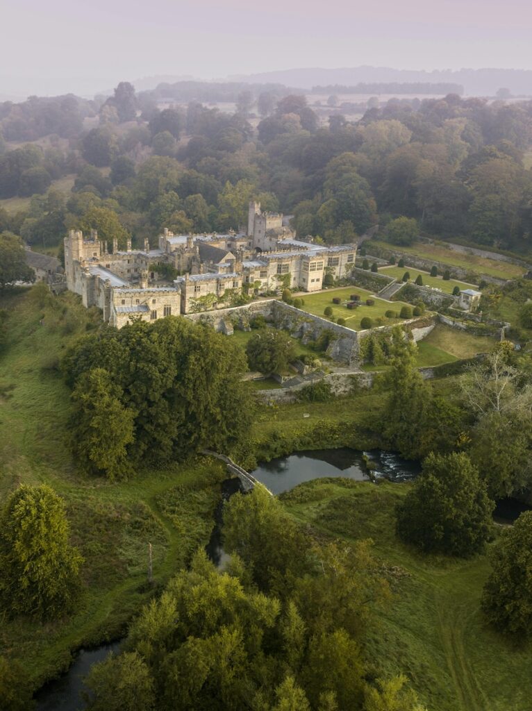 overhead view of Haddon Hall and gardens with backdrop of foggy countryside
