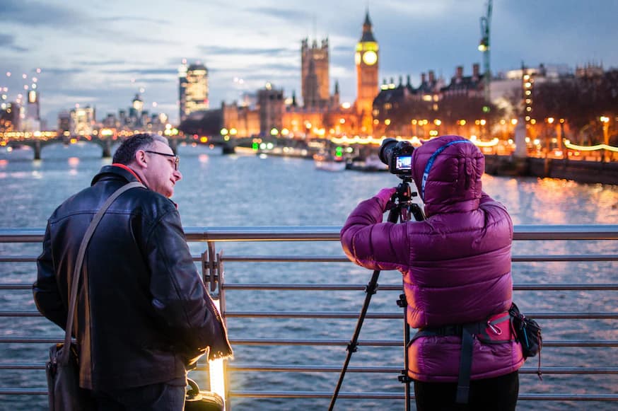 photographer on bridge shooting Westminster at dusk
