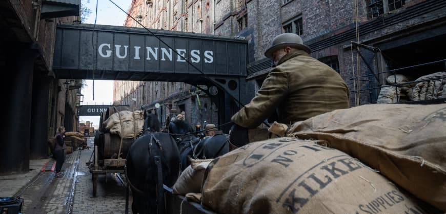 Film still from House of Guiness  showing a character on a horse-drawn carriage in the streets